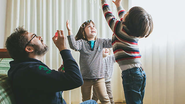 Father blowing bubbles with kids