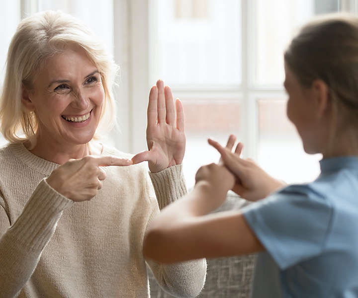 Nurse doing sign language with patient