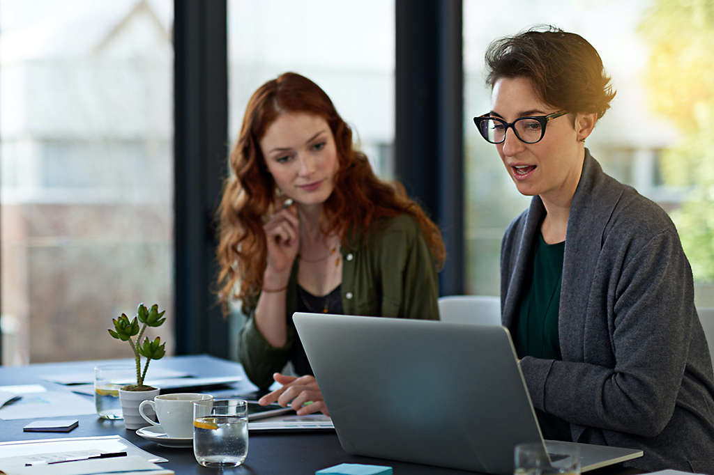 An employee working with a vocational coach at a workstation. 