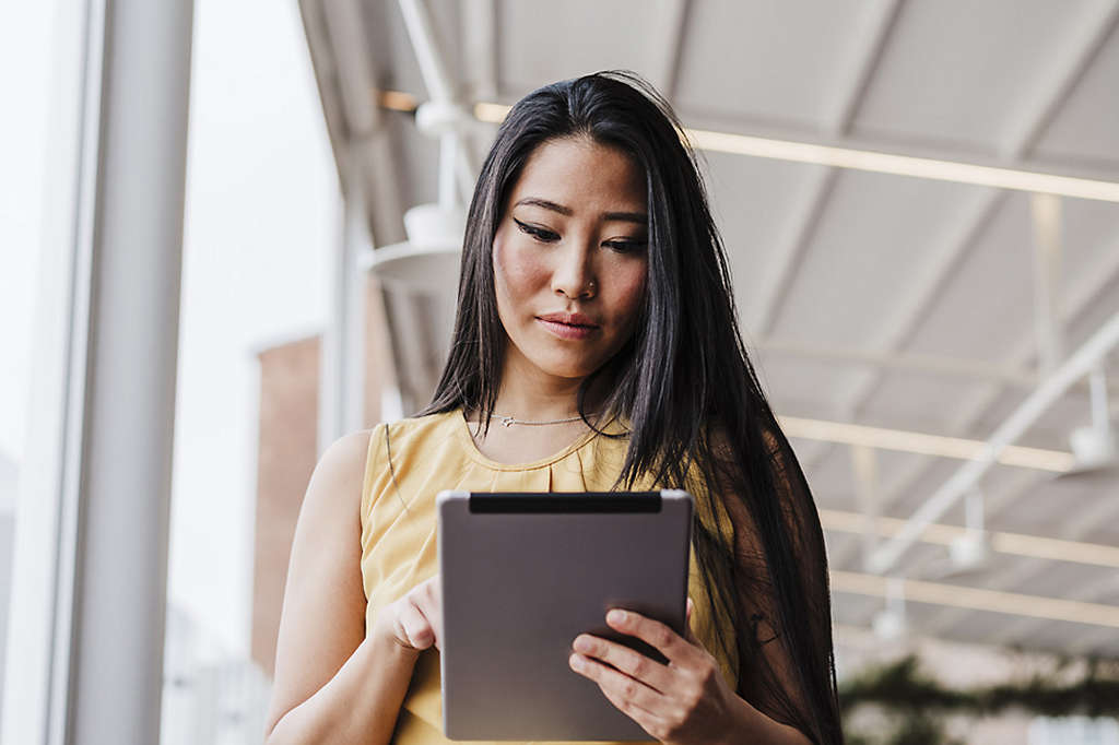 Single woman researching life insurance on her tablet