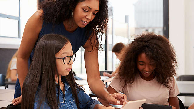 Teacher working with teenage students