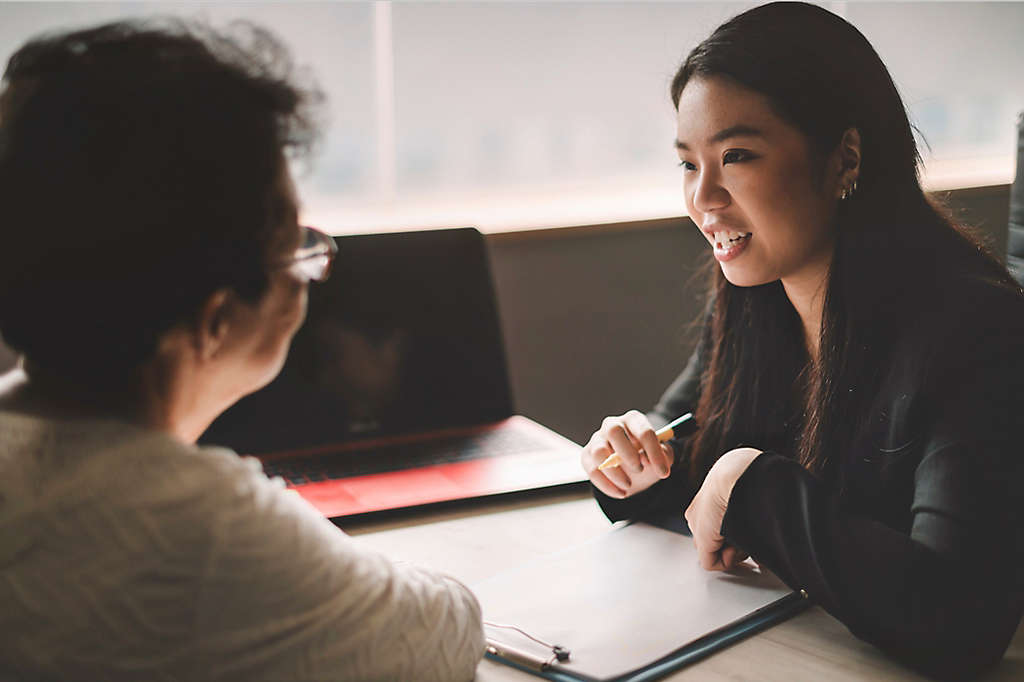 Active senior woman having discussion with agent about her retirement investment plan