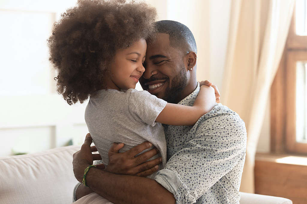 Father hugging young daughter