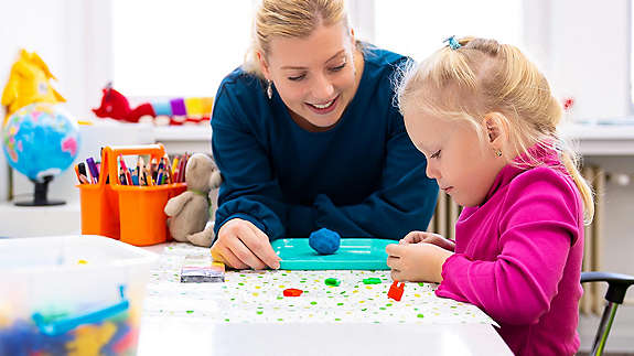 Teacher doing crafts with young girl