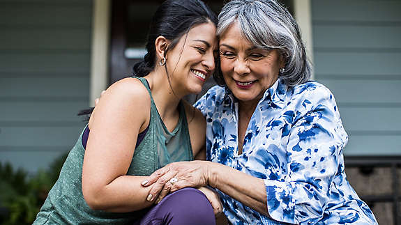 Mother and Daughter hugging on porch