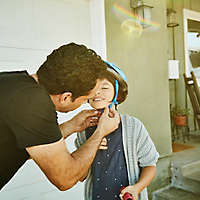 Father putting a bike helmet on his child.