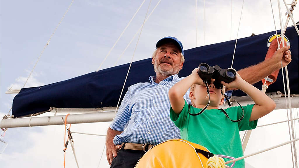 Grandfather teaching his grandchild about sailing