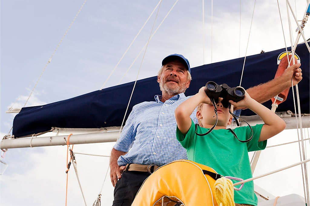Grandfather teaching his grandchild about sailing