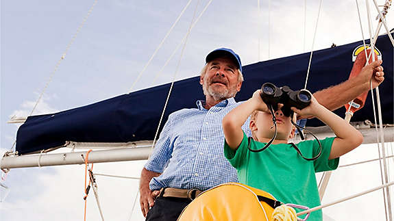 Grandfather teaching his grandchild about sailing