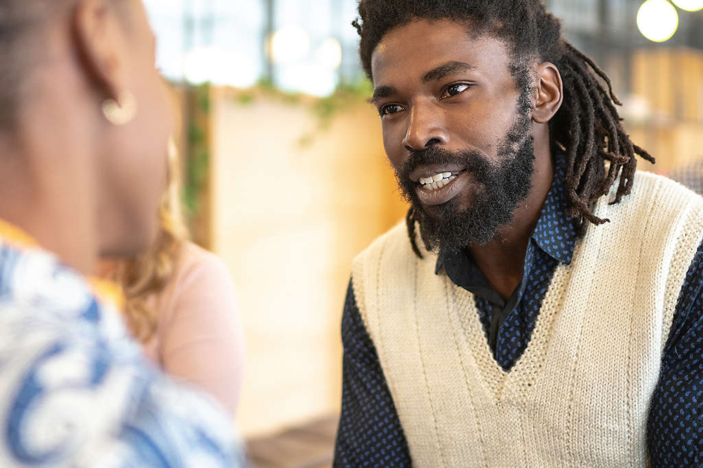 Man having a discussion with people in the background.