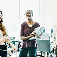 A group of people happily chatting at work.