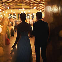 Newly married couple entering a reception hall.