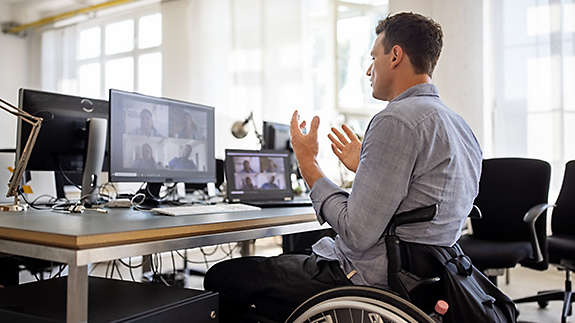 man-in-wheelchair-at-his-desk-on-a-teleconference-call