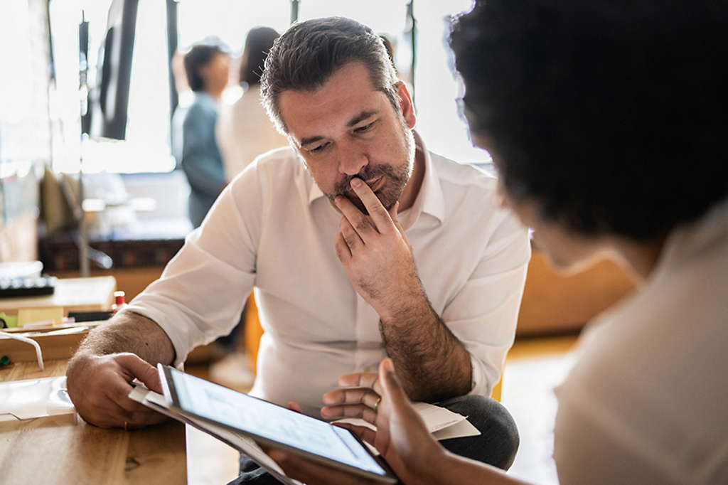 Man looking over financial projections on a tablet