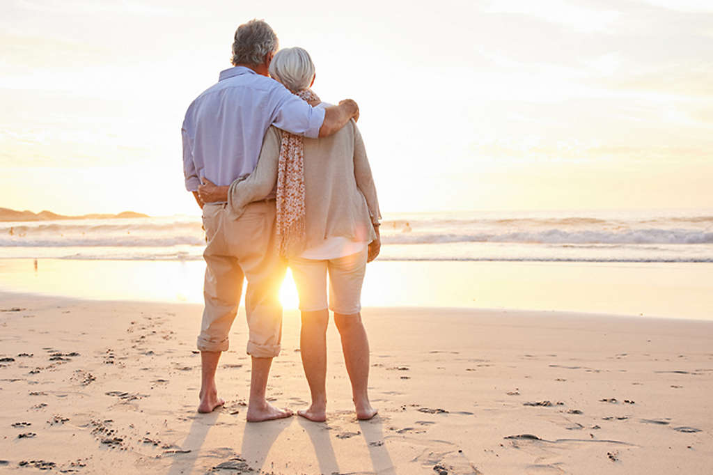 Older couple on the beach at sunset
