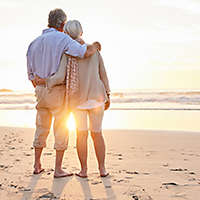 Older couple on the beach at sunset