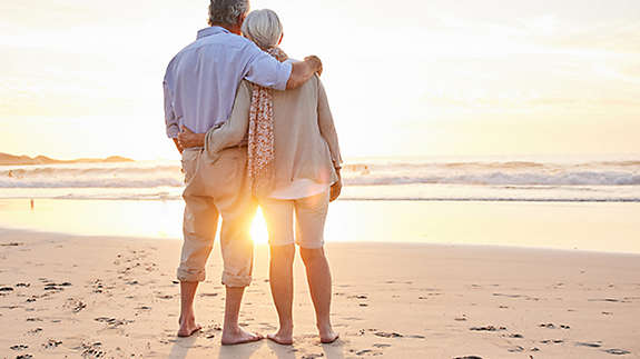 Older couple on the beach at sunset