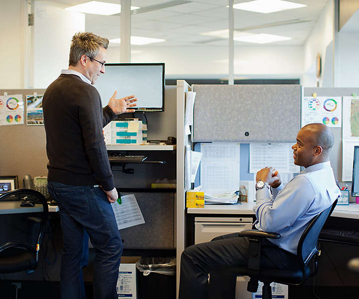 Co-workers meeting at desk