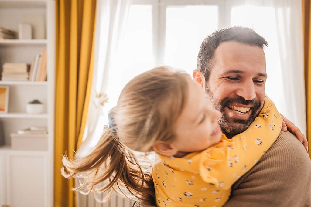 An older individual joyfully embracing a much younger individual.