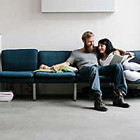 A couple sitting on the couch with their new baby.