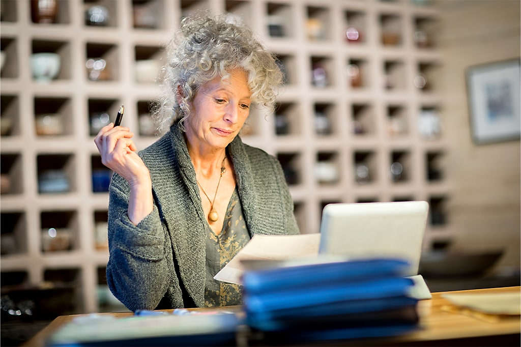 Woman researching online on a laptop comparing different types of trust options