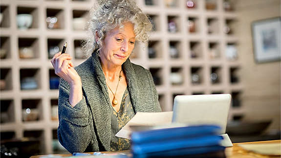 Woman researching online on a laptop comparing different types of trust options