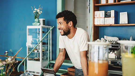 Barista smiling as he chats with customers in coffee shop