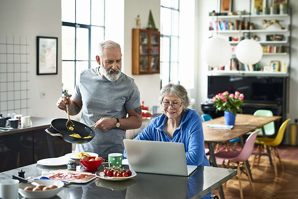 Older, retired couple cooking together in their kitchen