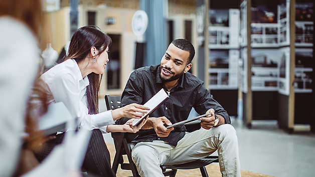 Two employees discussing documents related to enrollment experience