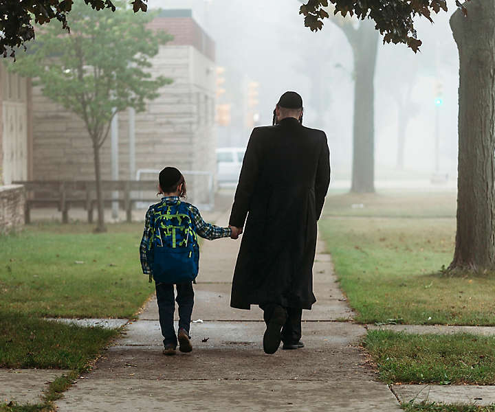 Hasidic father walking with son