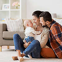  Parents smiling and holding their baby