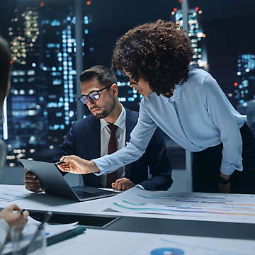 Colleagues working together in an office with a city landscape in the background