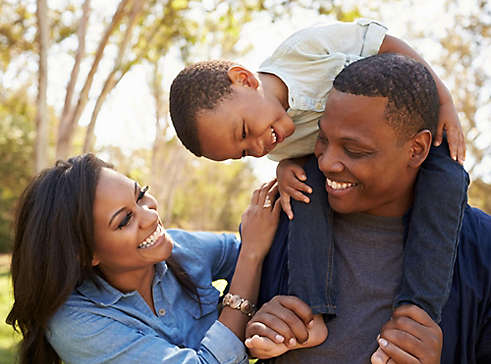 Young family smiling outside