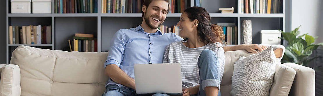 man and women on couch with computer