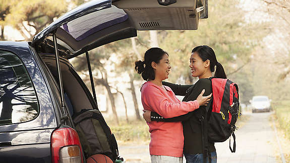 Mother hugging daughter before school