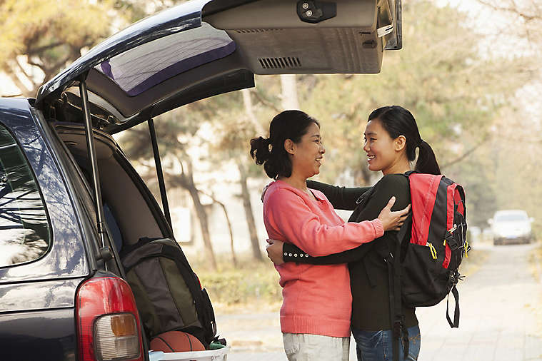 Mother hugging daughter before school