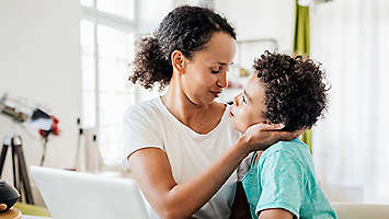 Mother and son together at a table.