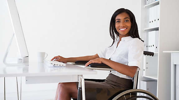 A women in a wheelchair working at her desk