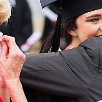 Parents hugging daughter at graduation ceremony