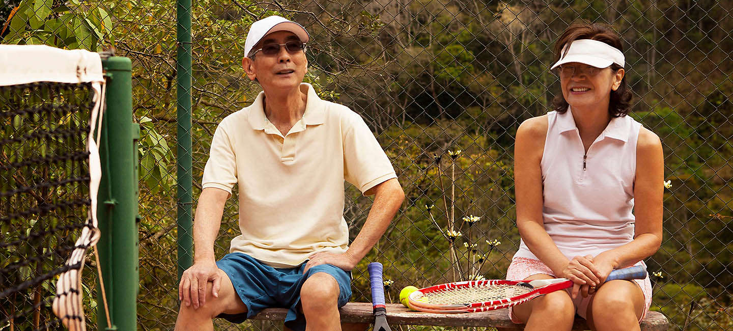 Older couple taking a break from a tennis game.