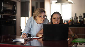 Two woman looking at laptop.