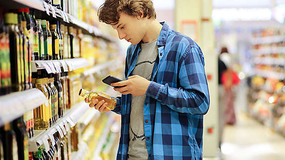 Young man in supermarket looking at items 