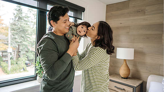 Parents kissing their baby