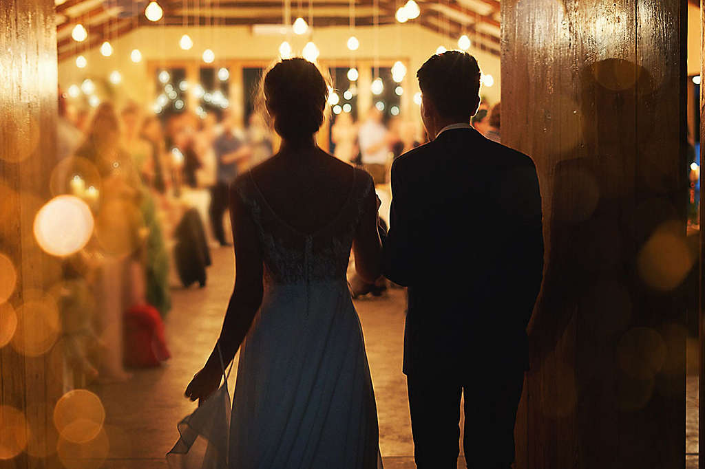 Married couple walking into their wedding reception.