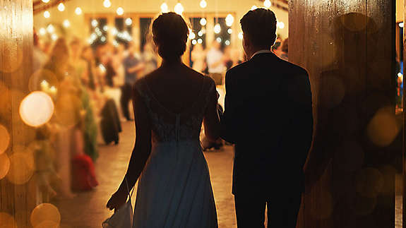 Married couple walking into their wedding reception.