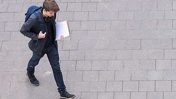 Student walking with book in hand 