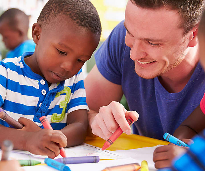 Teacher coloring with young boy