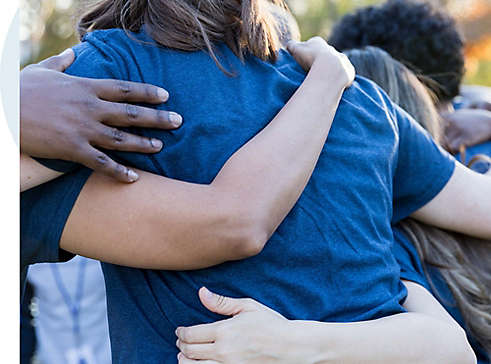 Diverse employee volunteers hugging