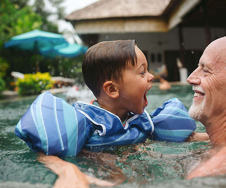 grandfather and grandson in pool