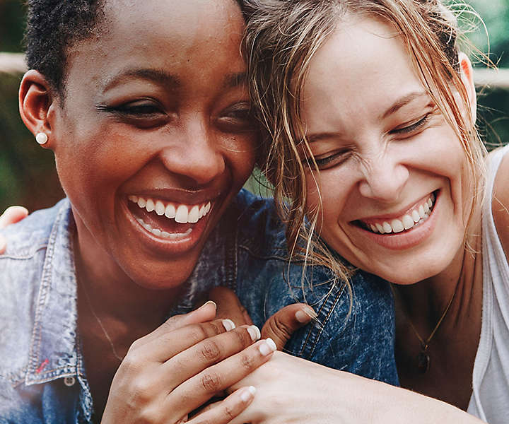 Two ladies laughing and smiling together